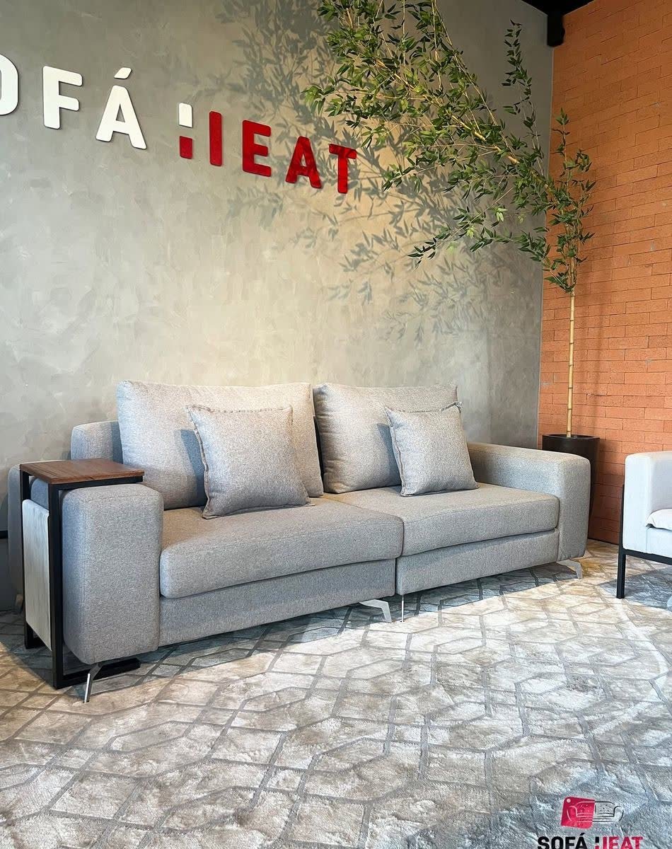 Showroom Sofá Heat com letreiro na parede de cimento, sofá cinza e bambu